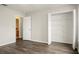 Bedroom with wood-look floors, closet with shelving, and doorway leading to bathroom at 123 Dresdan Ct, Sanford, FL 32771