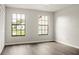 Bright bedroom featuring wood-look floors and two windows offering neighborhood views at 123 Dresdan Ct, Sanford, FL 32771