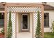 Close-up of a charming entryway with a decorative lattice, small trees, and a view of the front door at 123 Dresdan Ct, Sanford, FL 32771