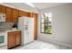 Functional kitchen with wood cabinets, white appliances, and a bright window providing natural light at 123 Dresdan Ct, Sanford, FL 32771