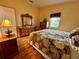 Bright bedroom with wood floors, a window, and a vintage-style dresser and mirror at 1234 E Schwartz Blvd, Lady Lake, FL 32159