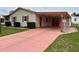 Charming home featuring a carport with red doors and an inviting covered entrance at 1234 E Schwartz Blvd, Lady Lake, FL 32159