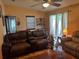 Comfortable living room features a ceiling fan, sliding glass door and a brown leather sofa set at 1234 E Schwartz Blvd, Lady Lake, FL 32159