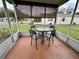 Relaxing screened patio with a round table and seating for four overlooking the yard at 1234 E Schwartz Blvd, Lady Lake, FL 32159