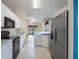 Modern kitchen with stainless steel appliances, white cabinets, and a view into the living area at 13219 Meadowlark Ln, Orlando, FL 32828