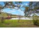 Picturesque lake view with a green lawn in the foreground and trees framing the water at 13219 Meadowlark Ln, Orlando, FL 32828