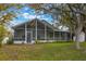 Lovely screened porch with a white frame and plants along the bottom creates an enjoyable outdoor space at 13219 Meadowlark Ln, Orlando, FL 32828