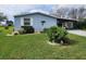 Charming light blue home with a well-manicured lawn and inviting landscaping at 1336 E Schwartz Blvd, Lady Lake, FL 32159