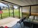 Serene screened patio with a table, chairs, and view of the well-manicured lawn at 1336 E Schwartz Blvd, Lady Lake, FL 32159