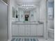 Bright bathroom featuring a double sink vanity, decorative wall art, and framed mirror above the sinks at 1377 Eagle Ridge Dr, The Villages, FL 32162