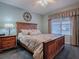 Bedroom showcases a wooden bed frame, side table, and large window, creating a cozy retreat at 1377 Eagle Ridge Dr, The Villages, FL 32162