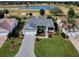 Aerial view of a single Gathering home with a well-manicured lawn and golf course and water view at 1377 Eagle Ridge Dr, The Villages, FL 32162