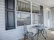 Inviting front porch with seating area, modern windows, and stylish shutters at 1377 Eagle Ridge Dr, The Villages, FL 32162