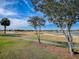 Picturesque golf course view with mature trees and serene water features under a bright blue sky at 1377 Eagle Ridge Dr, The Villages, FL 32162