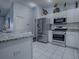 The bright kitchen features stainless steel appliances, granite counters, and white cabinets at 1377 Eagle Ridge Dr, The Villages, FL 32162