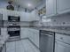 Well-lit kitchen featuring granite counters, stainless steel appliances, and white cabinetry at 1377 Eagle Ridge Dr, The Villages, FL 32162