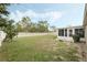 View of backyard with a white vinyl fence and a screened-in patio visible to the right at 140 Lake Catherine Cir, Groveland, FL 34736