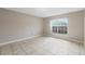 Bright and airy bedroom featuring tile flooring, base molding, and a large window at 140 Lake Catherine Cir, Groveland, FL 34736