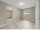 Neutral bedroom with tiled floor, natural light, and ensuite access at 140 Lake Catherine Cir, Groveland, FL 34736