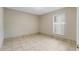 Inviting bedroom featuring tiled flooring, base molding, and a window at 140 Lake Catherine Cir, Groveland, FL 34736