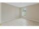 Minimalist bedroom featuring tiled flooring, neutral walls, base molding, and a window at 140 Lake Catherine Cir, Groveland, FL 34736