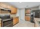 Well-lit kitchen with stainless steel appliances, tile backsplash, and ample counter space at 140 Lake Catherine Cir, Groveland, FL 34736