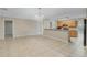 Bright living room showcasing an open layout with tile flooring, seamlessly connecting to the adjacent kitchen at 140 Lake Catherine Cir, Groveland, FL 34736