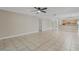 Spacious living room with tile flooring, ceiling fan, and a seamless transition to the modern kitchen at 140 Lake Catherine Cir, Groveland, FL 34736