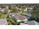 Overhead view of a home showcasing its roof, lanai, and landscaping within a vibrant neighborhood at 1508 Lakewood Dr, The Villages, FL 32162