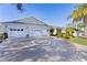 Home exterior featuring a circular driveway, attached garages, and manicured landscaping at 1508 Lakewood Dr, The Villages, FL 32162