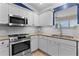 Well-lit kitchen featuring stainless steel appliances, a gas range, and classic white cabinets at 1508 Lakewood Dr, The Villages, FL 32162