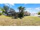 Wide backyard view showcasing a screened-in lanai, lush greenery, and ample space for outdoor activities at 15307 Petrus Ln, Clermont, FL 34714