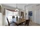 Cozy dining room featuring a wooden table, chandelier, and view of the front door and laundry area at 15307 Petrus Ln, Clermont, FL 34714