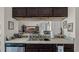 Kitchen sink and bar area overlooking the living room, featuring dark wood cabinetry and stainless appliances at 15307 Petrus Ln, Clermont, FL 34714