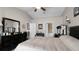 Bright bedroom with ceiling fan, dark wood furniture, and view of the ensuite bath and closet at 15307 Petrus Ln, Clermont, FL 34714