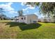 Spacious backyard with lush green grass and a well-maintained exterior of the home at 1623 W Schwartz Blvd, The Villages, FL 32159