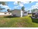 View of backyard with green grass, AC Unit, and side of house with window at 1623 W Schwartz Blvd, The Villages, FL 32159