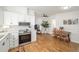 Open floor plan featuring a modern kitchen leading into the dining and living areas with hardwood floors at 1623 W Schwartz Blvd, The Villages, FL 32159