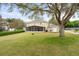 Residential house with screened patio and spacious yard, offering a great outdoor space for Gathering and entertaining at 16456 Meredrew Ln, Clermont, FL 34711