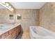 Bathroom features a double sink vanity and a soaking tub, providing a luxurious and functional space at 16456 Meredrew Ln, Clermont, FL 34711