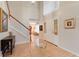 Bright foyer featuring tile floors, staircase with wooden banister, and a view into the living spaces at 16456 Meredrew Ln, Clermont, FL 34711