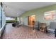 Screened patio with patterned tile flooring, seating and a ceiling fan with a view of the house and backyard at 16456 Meredrew Ln, Clermont, FL 34711