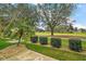 Backyard view with lush green grass, manicured bushes, and a scenic view of a golf course at 1732 Madero Dr, The Villages, FL 32159