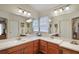 Primary bathroom with dual sinks, a spacious mirror, and decorative lighting at 1732 Madero Dr, Lady Lake, FL 32159