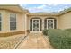 Welcoming entrance to this beige home featuring decorative screen doors and desert landscaping at 1732 Madero Dr, The Villages, FL 32159