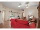 Bright living room featuring a red sofa, ceiling fan and sliding doors at 1732 Madero Dr, The Villages, FL 32159