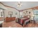 Comfortable bedroom featuring hardwood floors, a ceiling fan, and a view of the en suite bathroom at 1732 Madero Dr, Lady Lake, FL 32159