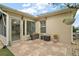 Outdoor patio area with stone flooring, greenery, and access to screened-in porch at 1732 Madero Dr, The Villages, FL 32159