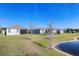 Backyard view of homes, lake, and green grass at 17369 Blazing Star Cir, Clermont, FL 34714