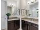 Modern dual vanity bathroom features dark cabinets, granite countertops, framed mirrors, and brushed nickel hardware at 17369 Blazing Star Cir, Clermont, FL 34714